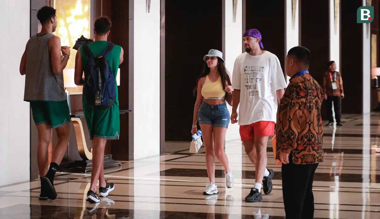 Pebasket Kanada, Dillon Brooks (tengah kanan) berjalan bersama sang kekasih, Danielle atau yang dikenal Big Bambina sambil membawa bungkusan di lobi hotel mereka menginap pada Kamis (24/08/2023). (Bola.com/Bagaskara Lazuardi)