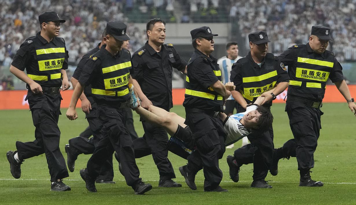 Seorang penyusup lapangan tertangkap petugas pada laga persahabatan antara Argentina melawan Australia di Workers' Stadium, Beijing, Kamis (15/06/2023). (AP Photo/Andy Wong)