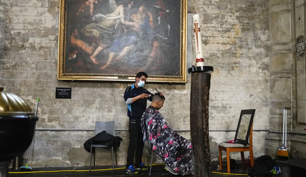 Seorang pria mogok makan menata rambutnya saat bersama yang lain menempati gereja Saint-Jean-Baptiste-au-Beguinage di Brussel, Senin (7/6/2021). Puluhan migran tanpa surat resmi dan yang telah menduduki gereja sejak Februari lalu telah memulai mogok makan sejak 23 Mei 2021. (AP Photo/Francisco Seco)