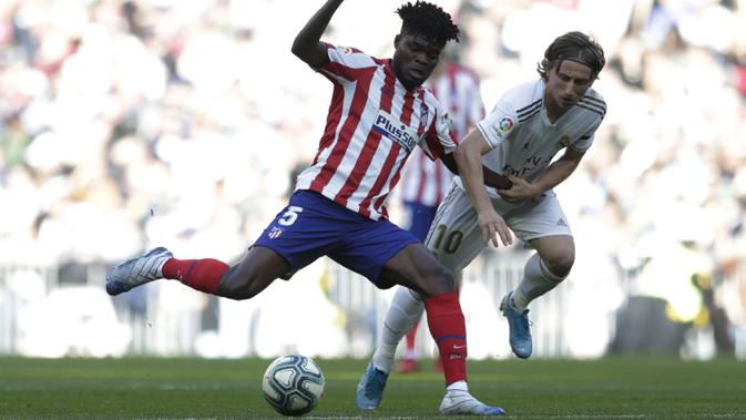 Gelandang Real Madrid, Luka Modric berusaha merebut bola yang dibawa gelandang Atletico Madrid, Thomas Partey pada pertandingan lanjutan La Liga Spanyol di stadion Santiago Bernabeu di Madrid, Sabtu, (1/2/2020). Real Madrid menang tipis 1-0 atas Atletico Madrid. (AP Photo/Bernat Armangue)