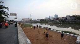 Sejumlah anak bermain sepak bola di sebuah lahan kosong di Pinggir Banjir Kanal Barat, Jakarta, Selasa (12/10/2021). Untuk mencari kesenangan, anak-anak memanfaatkan lahan pinggir BKB meski saat ini juga masih bahaya karena pandemi corona. (Liputan6.com/Johan Tallo)