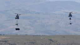 Helikopter Chinook Inggris membawa senjata artileri dan sebuah truk selama latihan militer Swift Response 22 di poligon pelatihan tentara Krivolak, Makedonia Utara, 12 Mei 2022. Latihan militer Swift Response 22 dilakukan untuk menunjukkan kemampuan negara-negara NATO siap ditempatkan di mana saja di seluruh dunia serta tentaranya dapat beroperasi bersama secara profesional dan sukses. (AP Photo/Boris Grdanoski)