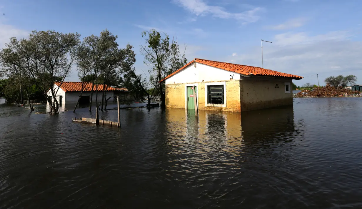 Sebuah rumah tampak terendam banjir yang melanda Asuncion, Paraguay, Senin (28/12). Banjir terparah dalam kurun waktu 23 tahun ini, bahkan telah membuat lebih dari 100.000 warga mengungsi. (REUTERS/Jorge Adorno)