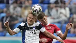 Penyerang Finlandia, Joel Pohjanpalo (kiri) berebut bola udara dengan bek Rusia, Igor Diveyev Finlandia pada pertandingan grup B Euro 2020 di stadion Gazprom Arena di St. Petersburg, Rusia, Rabu (16/6/2021). Hasil ini membuat jalan Rusia lolos ke babak 16 besar kembali terbuka. (AP Photo/Dmitri Love