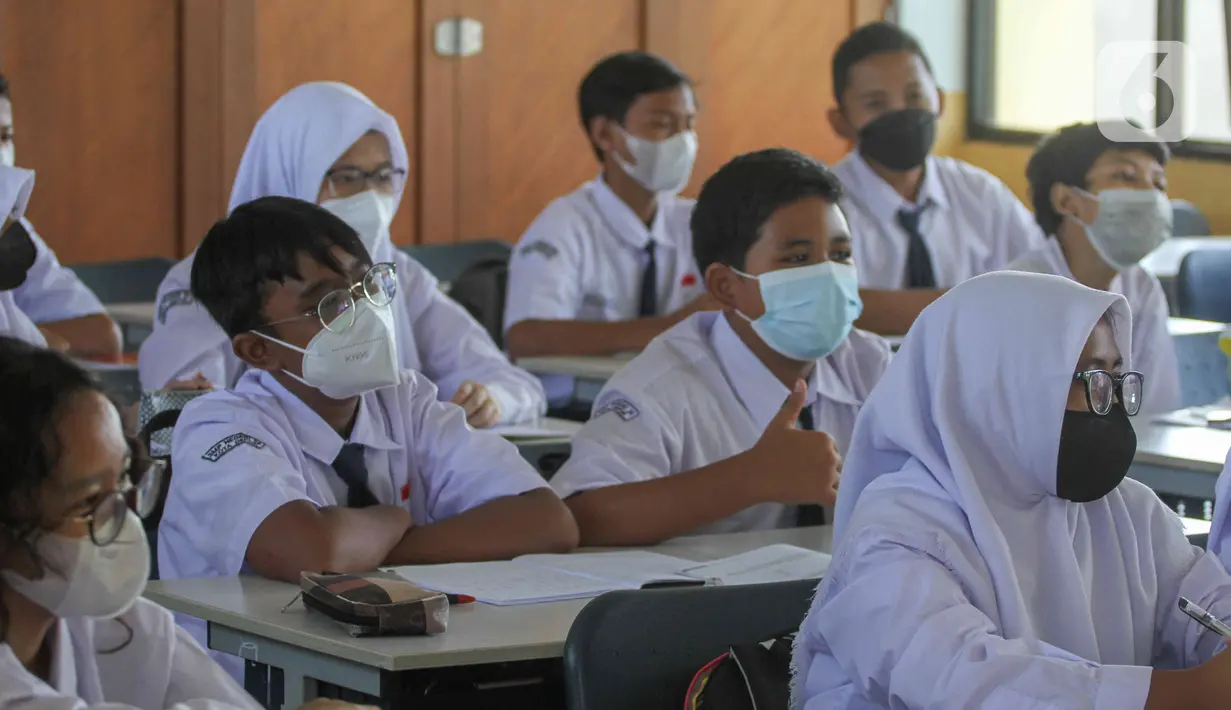 Siswa mengikuti kegiatan belajar mengajar pada hari pertama pembelajaran tatap muka di SMP 26 Depok, Depok, Jawa Barat, Senin (24/1/2022). Pemerintah Kota Depok mulai menggelar Pembelajaran Tatap Muka (PTM) secara penuh atau 100 persen mulai hari ini. (Liputan6.com/Herman Zakharia)