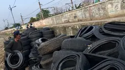 Pengepul mengumpulkan limbah ban bekas yang sudah dipotong di kawasan Tanah Abang, Jakarta, Rabu (27/12). (Liputan6.com/Immanuel Antonius)
