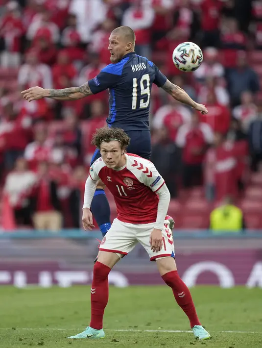 Gelandang timnas Finlandia, Joni Kauko (atas) berebut bola dengan penyerang Denmark, Andreas Skov Olsen pada laga Grup B Euro 2020 di Parken Stadium, Sabtu (12/6/2021). Selain tumbang 0-1, tuan rumah juga terpukul menyusul insiden yang melibatkan Christian Eriksen.  (AP Photo/Martin Meissner, Pool)
