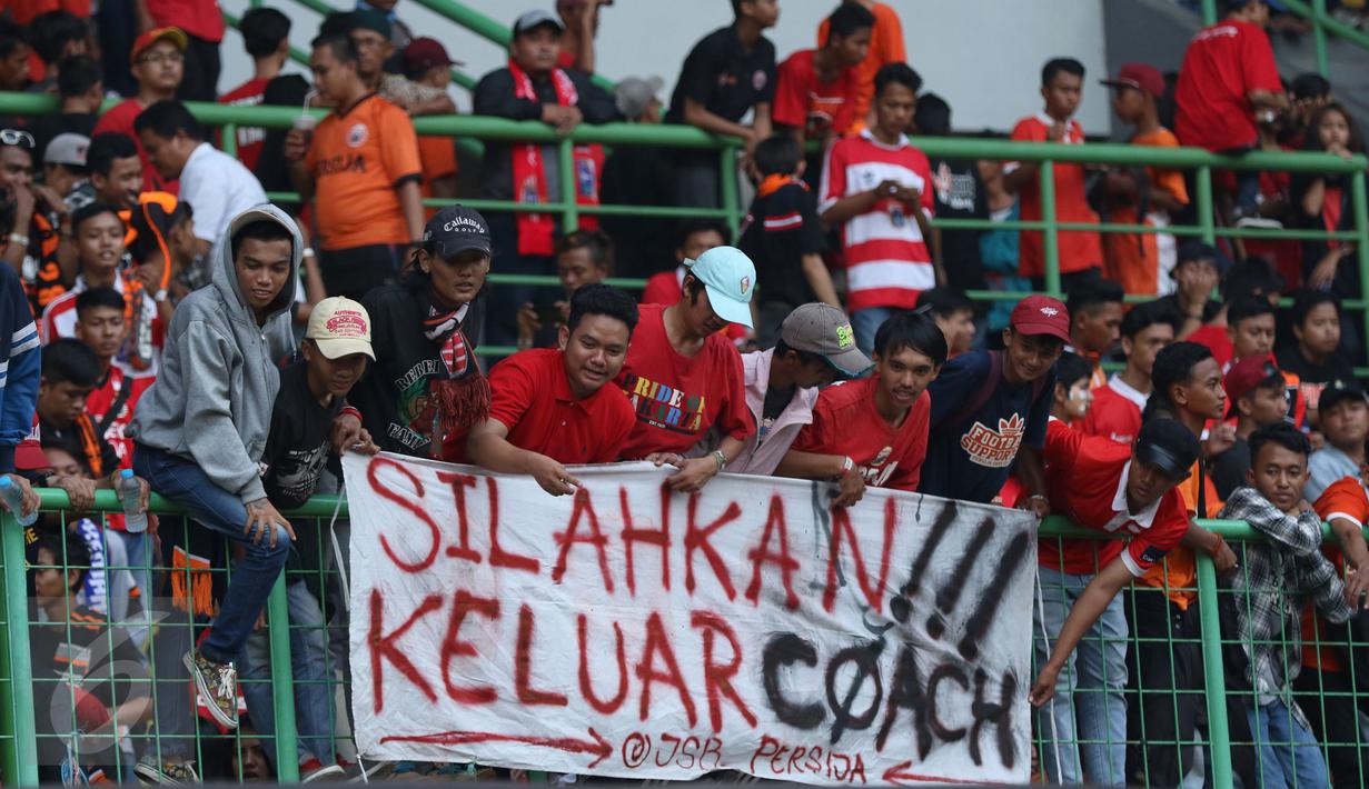 Suporter membentangkan spanduk protes usai menyaksikan laga Persija melawan Mitra Kukar pada lanjutan Liga 1 Indonesia di Stadion Patriot Candrabhaga, Bekasi, Minggu (14/5). Laga kedua tim berakhir imbang 1-1. (Liputan6.com/Helmi Fithriansyah)