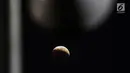 Foto fenomena gerhana bulan total di kota Jakarta, Sabtu (28/7). Gerhana bulan total "Micro Blood Moon" tersebut merupakan yang terlama pada abad ini dengan total waktu termasuk fase penumbra dan parsial selama enam jam lebih. (Liputan6.com/Johan Tallo)