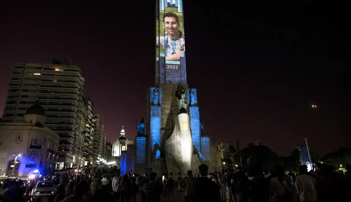Video mapping memperlihatkan gambar bintang sepak bola Argentina Lionel Messi di "Monumento Nacional a la Bandera" di Rosario, Senin (21/11/2022). Proyeksi tersebut mengulas gambar Messi di berbagai Piala Dunia yang dimainkan dari tahun 2006 hingga sekarang. (Marcelo Manera / AFP)