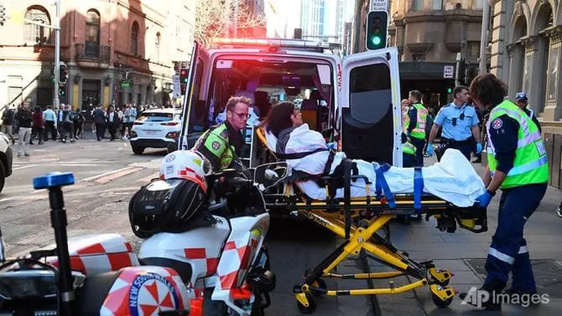 Seorang wanita dibawa dengan ambulans dari Hotel CBD di sudut King and York Street, setelah seorang pria berusaha menikam beberapa orang di Sydney, Australia pada 13 Agustus 2019. (Dean Lewins / AP)