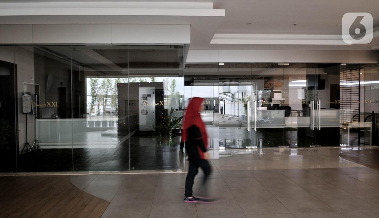 Pengunjung melintas di depan Cinema XXI di salah satu pusat perbelanjaan kawasan Jakarta Timur, Senin (23/3/2020). Guna mencegah penyebaran Covid-19, bioskop Cinema XXI di DKI Jakarta dan beberapa kota di Indonesia ditutup sementara mulai hari ini hingga 5 April 2020. (merdeka.com/Iqbal S. Nugroho)