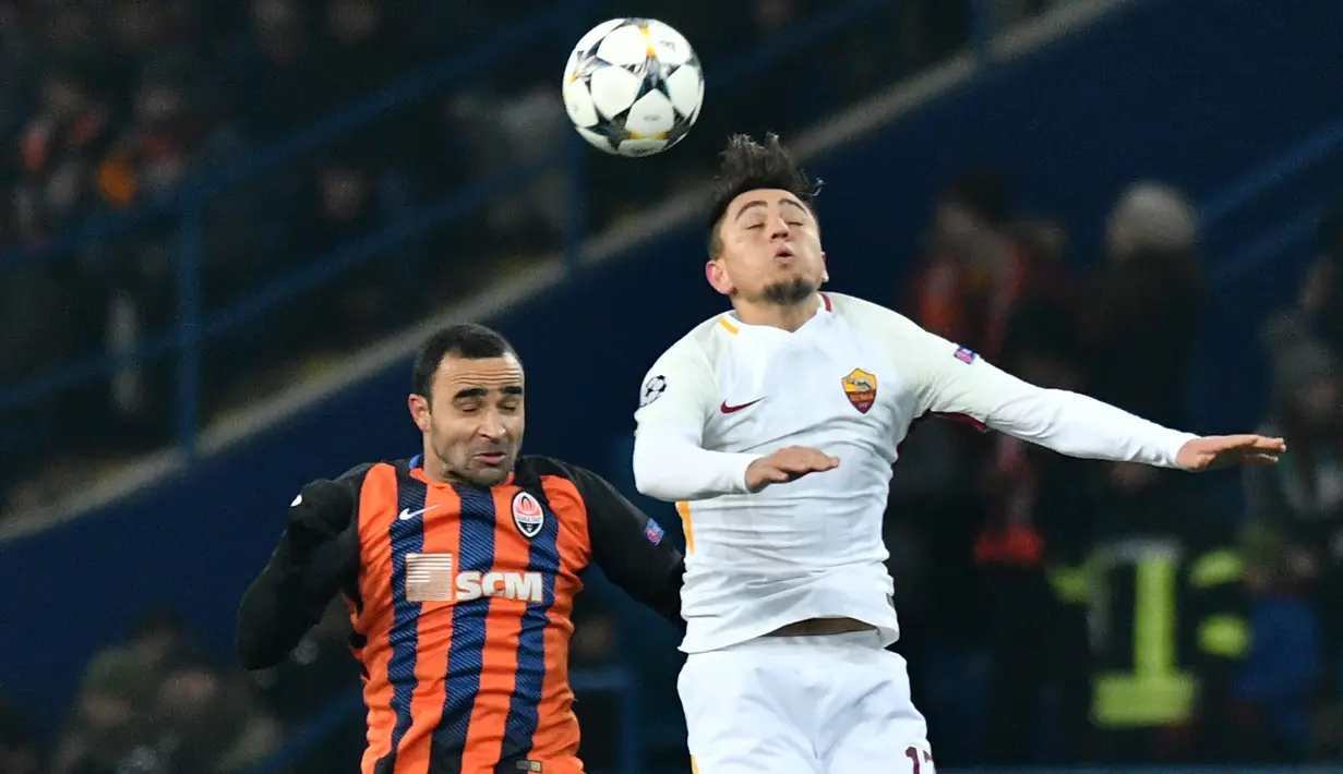 Pemain Shakhtar Donetsk, Shakhtar Donetsk Ismaily dan pemain  AS Roma, Cengiz Under berebut bola pada leg pertama babak 16 besar Liga Champions di Oblasny SportKomplex Metalist, Kamis (22/2). Shakhtar Donetsk sukses menang tipis 2-1. (GENYA SAVILOV/AFP)