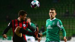 Gelandang Eintracht Frankfurt, Amin Younes (kiri) mengontrol bola di depan gelandang Werder Bremen, Maximilian Eggestein dalam laga lanjutan Liga Jerman 2020/21 pekan ke-23 di Weserstadion, Bremen, Jumat (26/2/2021). Eintracht Frankfurt kalah 1-2 dari Werder Bremen. (AFP/Patrik Stollarz/Pool)