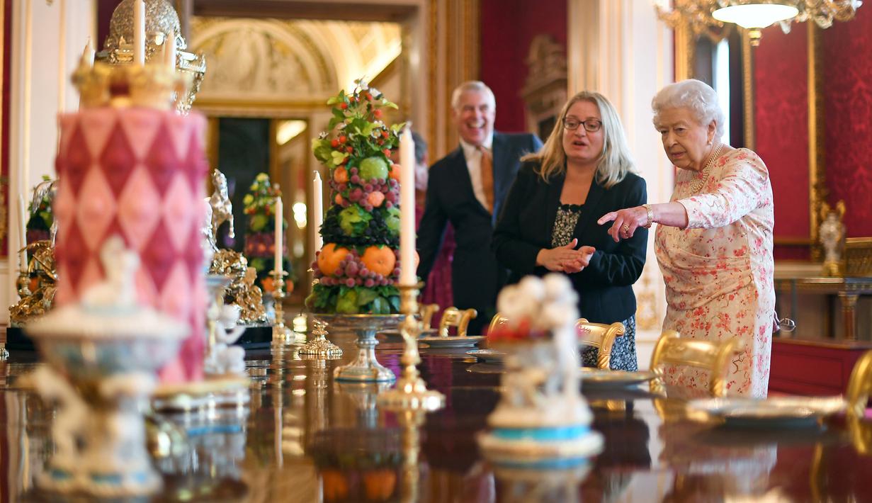 <p>Ratu Inggris Elizabeth II melihat penataan makanan penutup yang biasa dimakan Ratu Victoria sebagai bagian dari pameran di Istana Buckingham, London, Rabu (17/7/2019). Pameran yang dibuka pada 20 Juli ini menandai peringatan 200 tahun kelahiran Ratu Victoria. (Victoria Jones/POOL/AFP)</p>