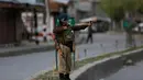 Seorang tentara paramiliter India menggunakan ketapel selama bentrok dengan pengunjuk rasa selama protes terhadap pembunuhan pemberontak di Srinagar, Kashmir yang dikuasai India, (1/4). (AP Photo / Dar Yasin)