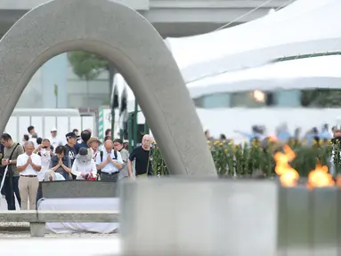Orang-orang berdoa untuk para korban bom atom di Hiroshima Peace Memorial Park, pusat kota Hiroshima, Jepang, Selasa (5/8/2019). Pemerintah Jepang menggelar peringatan jatuhnya bom atom di Kota Hiroshoma 74 tahun lalu yang menandai berakhirnya Perang Dunia (PD) II. (JIJI PRESS / AFP)