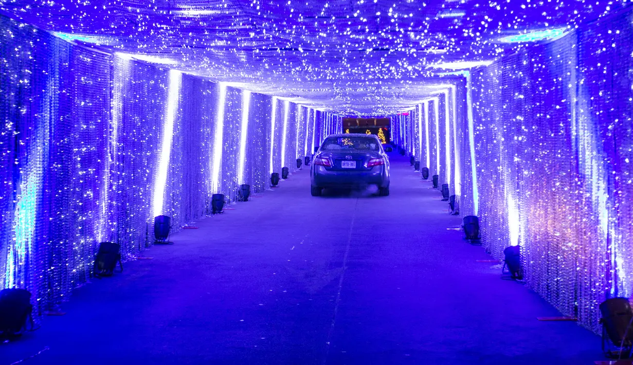 Para pengunjung mengendarai mobil mereka untuk melintasi terowongan yang bertabur cahaya di pertunjukan cahaya lantatur (drive-thru) bertema Natal "Polar Drive" di Toronto, Kanada, pada 15 Desember 2020. Pertunjukan lampu tersebut digelar dengan konsep drive-thru. (Xinhua/Zou Zheng)
