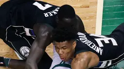 Pemain Boston Celtics, Marcus Smart (bawah) berebut bola dengan dua pemain Milwaukee Bucks pada laga playoffs NBA basketball di TD Garden, Boston, (24/4/2018). Celtics menang  92-87. (AP/Charles Krupa)