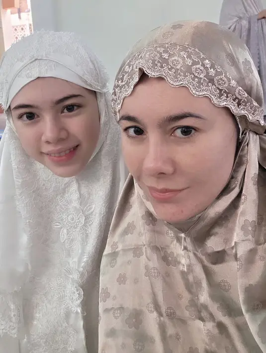 Wulan Guritno tampil mengenakan mukena shining coklat bermotif dengan wajah barefacenya. Tampak sang putri tercinta mendampinginya. [@wulanguritno]