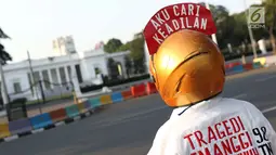 Aktivis yang tergabung dalam Jaringan Solidaritas Korban untuk Keadilan menatap ke arah Istana Negara saat aksi Kamisan, Jakarta, Kamis (25/7/2019). Aksi Kamisan ke-594 mengangkat tema '23 Tahun Tragedi 27 Juli Saat Jadi Penguasa Kok Malah Tidak Peduli?'. (Liputan6.com/Helmi Fithriansyah)