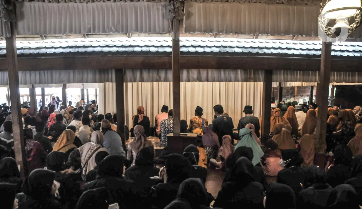 Umat muslim berdoa saat berziarah di Makam Sunan Kudus, Kauman, Kabupaten Kudus, Jawa Tengah, Rabu (30/3/2022). Humas Yayasan Masjid, Menara, dan Makam Sunan Kudus, Denny Nur Hakim mencatat jumlah peziarah mengalami peningkatan menjelang bulan Ramadan tahun ini. (merdeka.com/Iqbal S. Nugroho)
