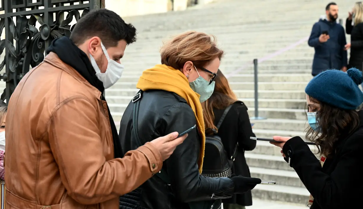 Pengunjung menunjukkan "Green Pass" di pintu masuk monumen Altare della Patria di Piazza Venezia, Roma, Minggu (5/12/2021). Kota Roma memberlakukan kewajiban penggunaan masker di ruang terbuka pusat kota dan area perbelanjaan sibuk lainnya hingga 31 Desember mendatang. (Vincenzo PINTO/AFP)