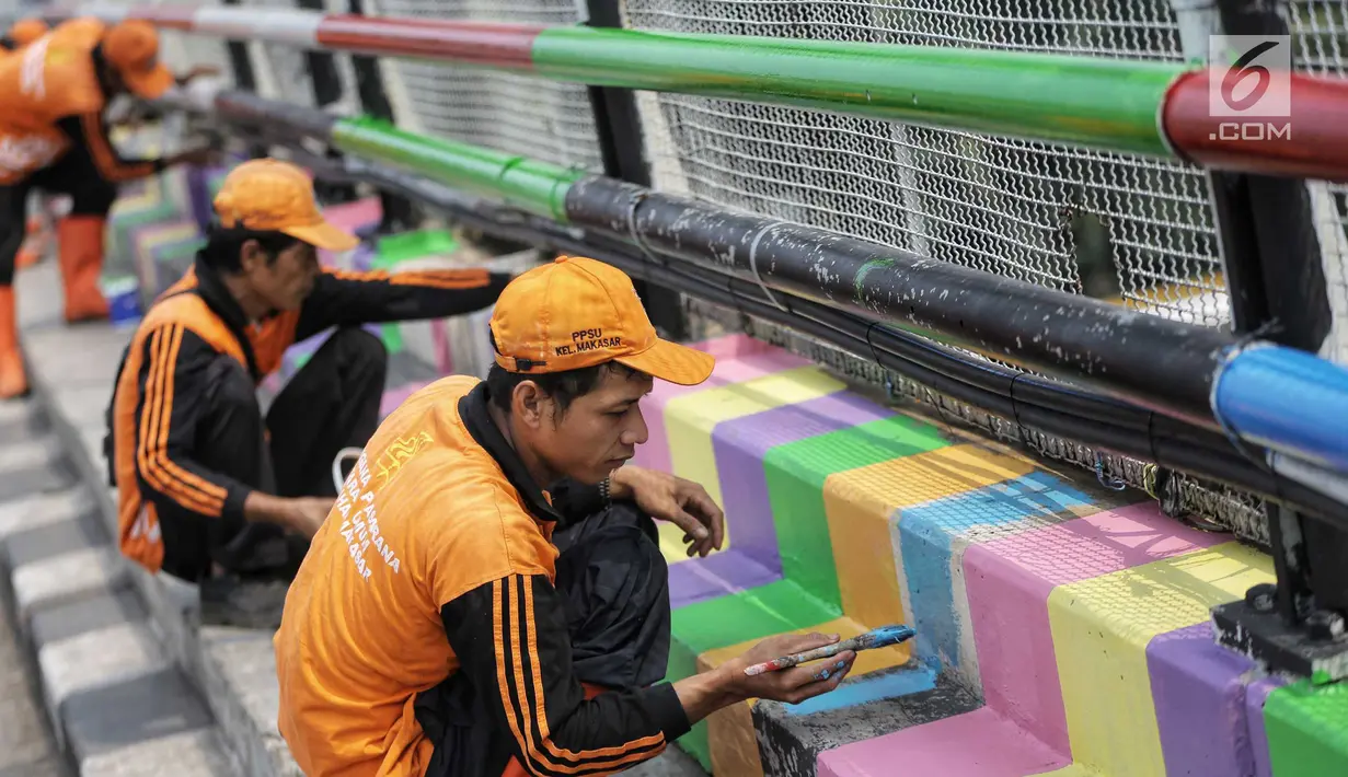 Pasukan oranye atau PPSU melakukan pengecatan jembatan layang dengan warna-warna ceria di Kampung Makasar, Jakarta, Kamis (26/7).  Pengecatan dilakukan guna mempercantik dan menyambut Asian Games 2018 pada Agustus mendatang.  (Liputan6.com/Faizal Fanani)