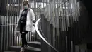 Seorang wanita yang mengenakan masker berjalan menuruni tangga di kompleks perbelanjaan dan perkantoran di Beijing, China, 13 April 2022. Shanghai telah membebaskan lebih dari 6.000 orang lagi dari observasi medis di tengah wabah COVID-19. (AP Photo/Mark Schiefelbein)