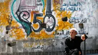 Seorang pria duduk-duduk saat Hari Nakba di kamp pengungsian Al-Shati, Jalur Gaza, Palestina, Rabu (15/5/2019). Hari Nakba diperingati untuk mengenang ketika ratusan ribu rakyat Palestina diusir dari rumah-rumah mereka agar negara Israel bisa berdiri. (MOHAMMED ABED/AFP)