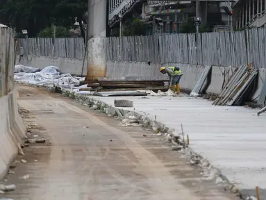 Pekerja menggarap penataan jalan dan trotoar di Jalan Sudirman, Jakarta, Selasa (17/4). Revitalisasi jalan dan trotoar tersebut sebagai persiapan Asian Games 2018 yang akan berlangsung di Jakarta pada Agustus 2018 mendatang. (Liputan6.com/Arya Manggala)