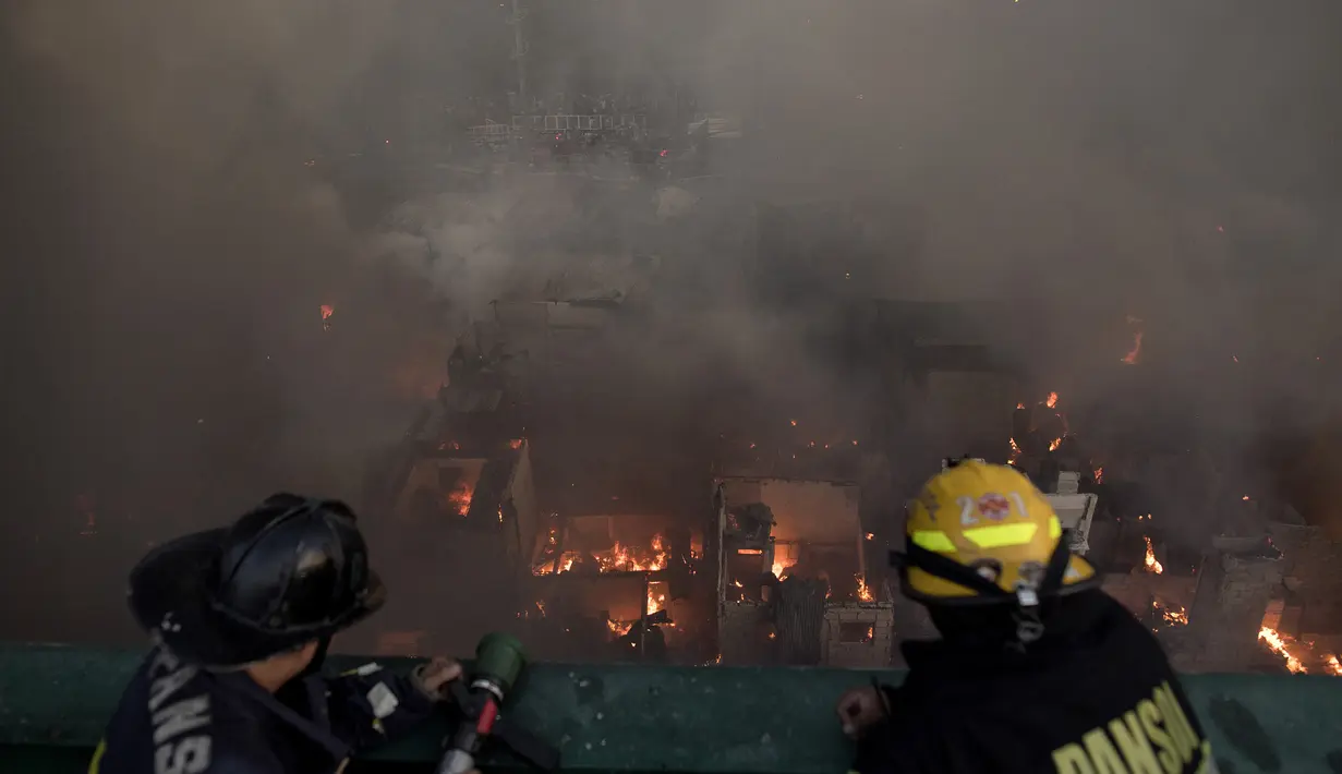 Petugas pemadam kebakaran berusaha memadamkan api yang melanda daerah kumuh di Manila, Filipina (23/5). Menurut laporan media setempat, kebakaran tersebut menghancurkan 200 rumah yang mempengaruhi 300 keluarga. (AFP Photo/Noel Celis)