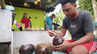 Eman Gani sedang membuat kerajinan tempurung kelapa di rumahnya di Kelurahan Bulotadaa Timur, Kecamatan Sipatana, Kota Gorontalo. (Liputan6.com/ Arfandi Ibrahim)