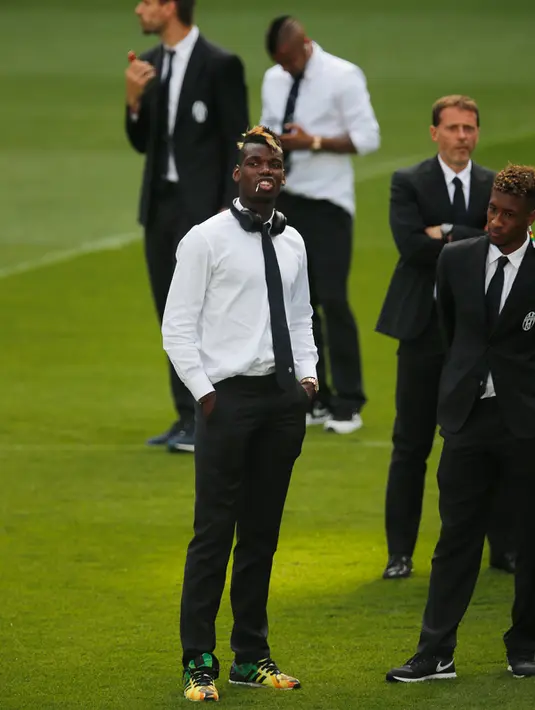 Gelandang Juventus, Paul Pogba bergaya mengenakan kemeja putih, dasi jelang konferensi pers di Stadion Santiago Bernabeu, Spanyol (12/5/2015). Juventus akan menantang Real Madrid di leg kedua semifinal Liga Champions.  (Reuters/Sergio Perez)
