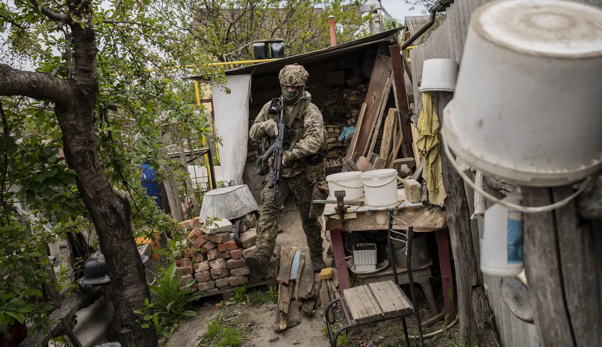 <p>Seorang tentara Pengawal Nasional Ukraina berpatroli selama misi pengintaian di sebuah desa yang baru saja direbut kembali di pinggiran Kharkiv, Ukraina timur, Sabtu, 14 Mei 2022. Militer Ukraina membuat pernyataan pada Selasa (10/5) bahwa pasukannya telah merebut kembali desa-desa dari pasukan Rusia di utara dan timur laut Kharkiv. (AP Photo/Bernat Armangue)</p>