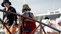 Turis China menggunakan masker saat tiba di Nusa Penida, Bali. (dok. foto SONNY TUMBELAKA/AFP)