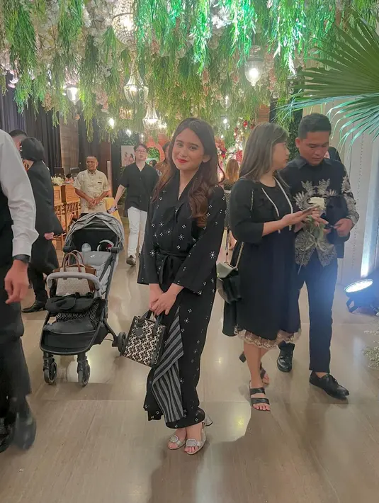 Melengkapi penampilannya, Tissa Biani tenteng handbag hitam dari Kate Spade dan heels silver [@tissabiani]