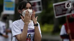Aktivis yang tergabung dalam Serikat Buruh Migran Indonesia (SBMI) melakukan aksi damai di Kawasan Monas, Jakarta Pusat, Minggu (13/3/2022). Mereka meminta agar pekerja perempuan diberikan hak yang sama seperti pekerja laki-laki dan tidak ada lagi tindakan diskriminasi. (Liputan6.com/Johan Tallo)