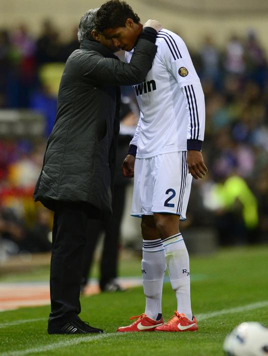 Jose Mourinho (kiri) berbisik kepada pemain belakang Real Madrid, Raphael Varane saat melawan  Club Atletico de Madrid pada laga La Liga di Vicente Calderon stadium, Madrid (27/4/2013). (AFP/ Javier Soriano).