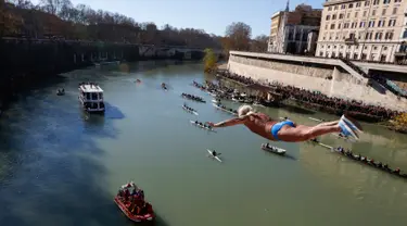 Maurizio Palmulli dari Italia melakukan terjun bebas ke sungai Tiber dari Jembatan Cavour di Roma, Selasa (1/1). Tradisi melompat dari jembatan setinggi 18 meter  dan menyelam ke sungai tersebut sebagai bentuk perayaan tahun baru. (AP/Riccardo De Luca)