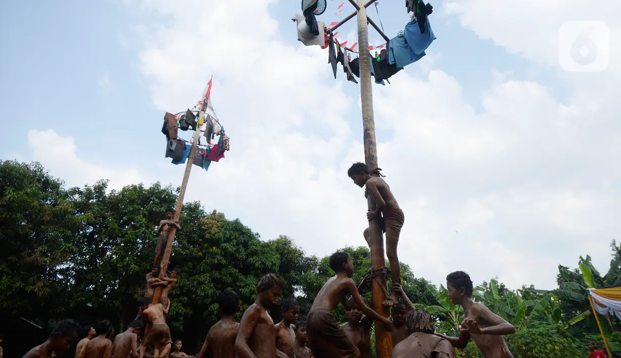 Peserta berusaha memanjat hadiah dalam perlombaan panjat pinang di Kampung Bulak, Kelurahan Benda Baru, Pamulang, Tangerang Selatan, Senin (17/8/2020). Lomba di tengah masa pandemi itu guna memeriahkan HUT ke-75 Kemerdekaan RI. (merdeka.com/Dwi Narwoko)