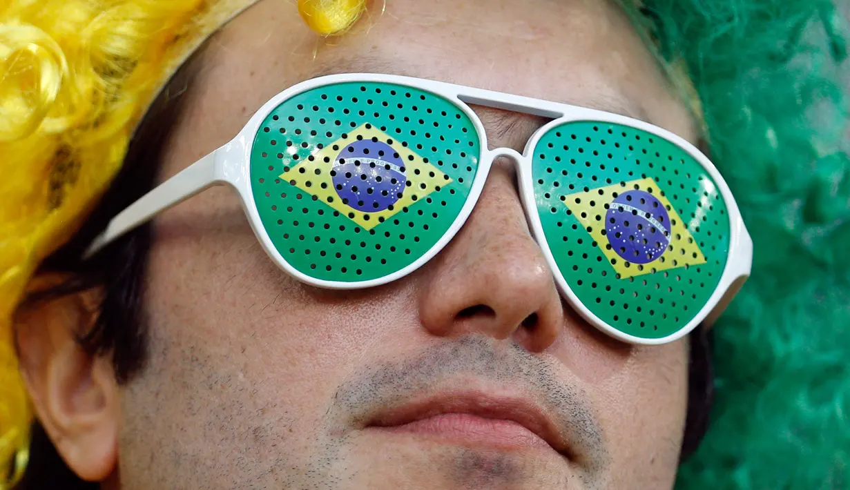 Suporter Brasil menggunakan kacamata unik menunggu dimulainya laga terakhir penyisihan grup E Piala Dunia 2018 melawan Serbia di Stadion Spartak, Rusia, Rabu (27/6). Brasil sukses melaju ke babak 16 besar usai menang 2-0. (AP Photo/Victor R. Caivano)