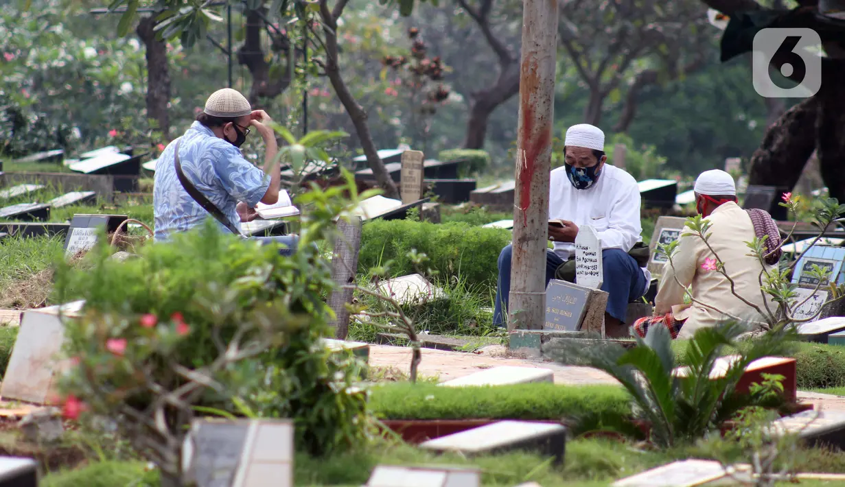 Peziarah membaca doa di salah satu makam di Tempat Pemakaman Umum Karet Bivak, Jakarta, Sabtu (18/4/2020). Selama masa PSBB, peziarah yang memasuki kawasan TPU dibatasi dan diwajibkan menggunakan masker sebagai langkah pencegahan penyebaran virus Covid-19. (Liputan6.com/Helmi Fithriansyah)