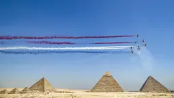 Pesawat K-8E Karakorum dari tim aerobatic "Silver Stars" Angkatan Udara Mesir tampil selama Pyramids Air Show 2022 di atas (kanan ke kiri) Great Pyramid of Khufu, Pyramid of Khafre, dan Pyramid of Menkaure di Giza Pyramids Necropolis, Mesir, 3 Agustus 2022. (Mahmoud Khaled/AFP)