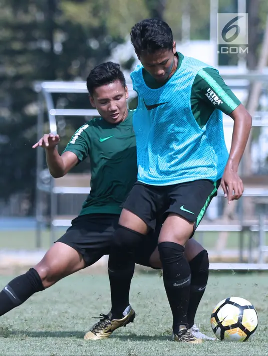 Pemain Timnas Indonesia U-19, Syahrian Abimanyu (kiri) berebut bola dengan rekannya saat latihan di Lapangan B Kompleks GBK, Jakarta, Selasa (18/9). Latihan ini persiapan  PSSI Anniversary Cup U-19 dan Piala AFC U19. (Liputan6.com/Helmi Fithriansyah)