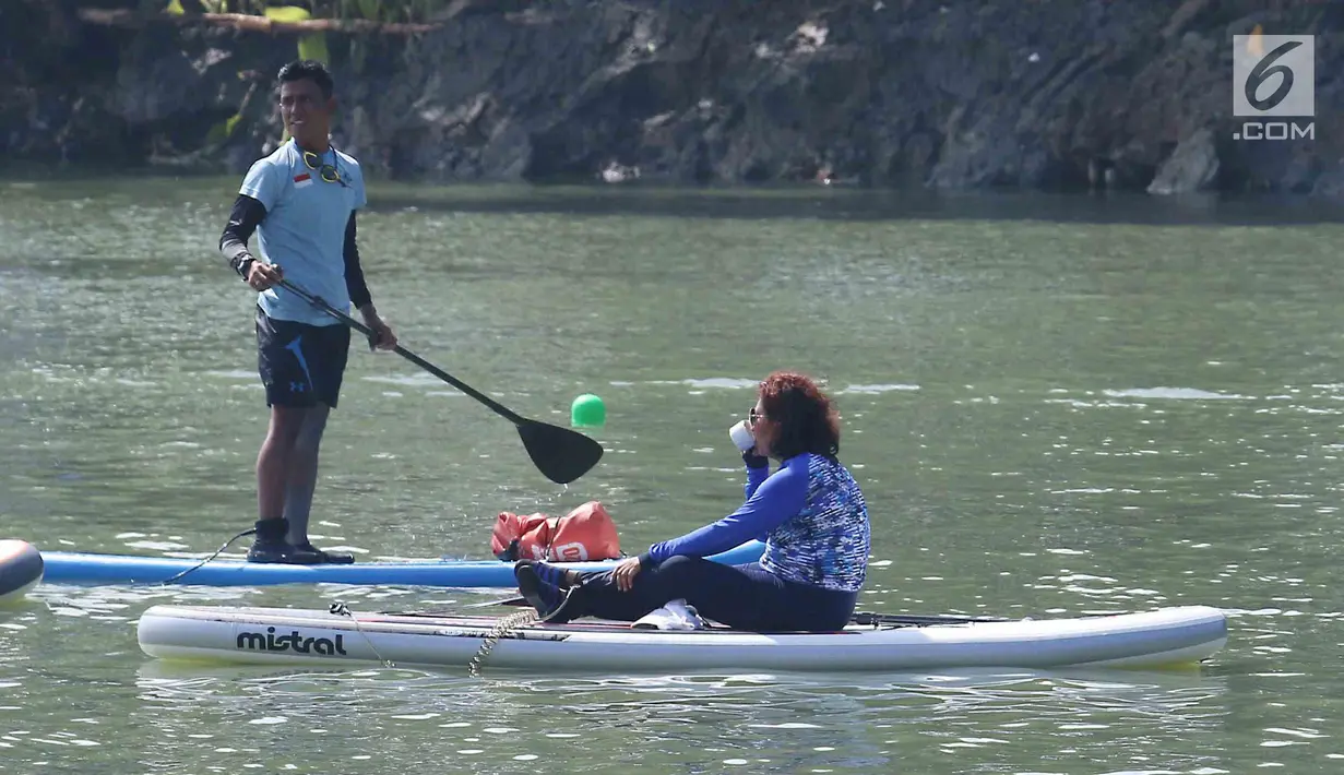 Menteri Kelautan dan Perikanan Susi Pudjiastuti meminum kopi saat bertanding melintasi danau sepanjang 1k melawan Wakil Gubernur DKI Jakarta Sandiaga Uno selama Festival Danau Sunter di Jakarta, Minggu (25/2). (Liputan6.com/Angga Yuniar)
