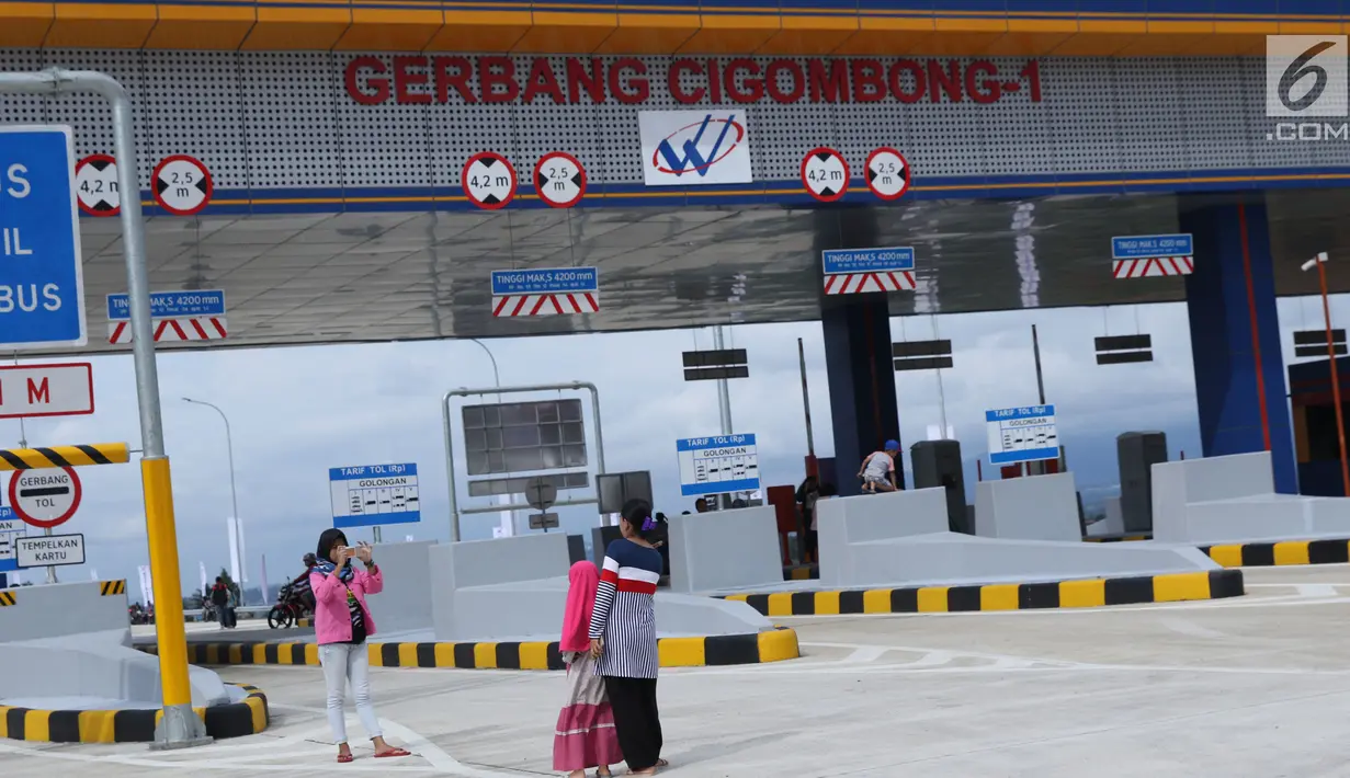 Warga berfoto berlatar gerbang tol Cigombong I di Cigombong, Kab Bogor, Jawa Barat, usai diresmikan, Sabtu (1/12). Ruas panjang tol Ciawi-Sukabumi Seksi I Ciawi-Cigombong sejauh 15,3 kilometer. (Liputan6.com/Helmi Fithriansyah)