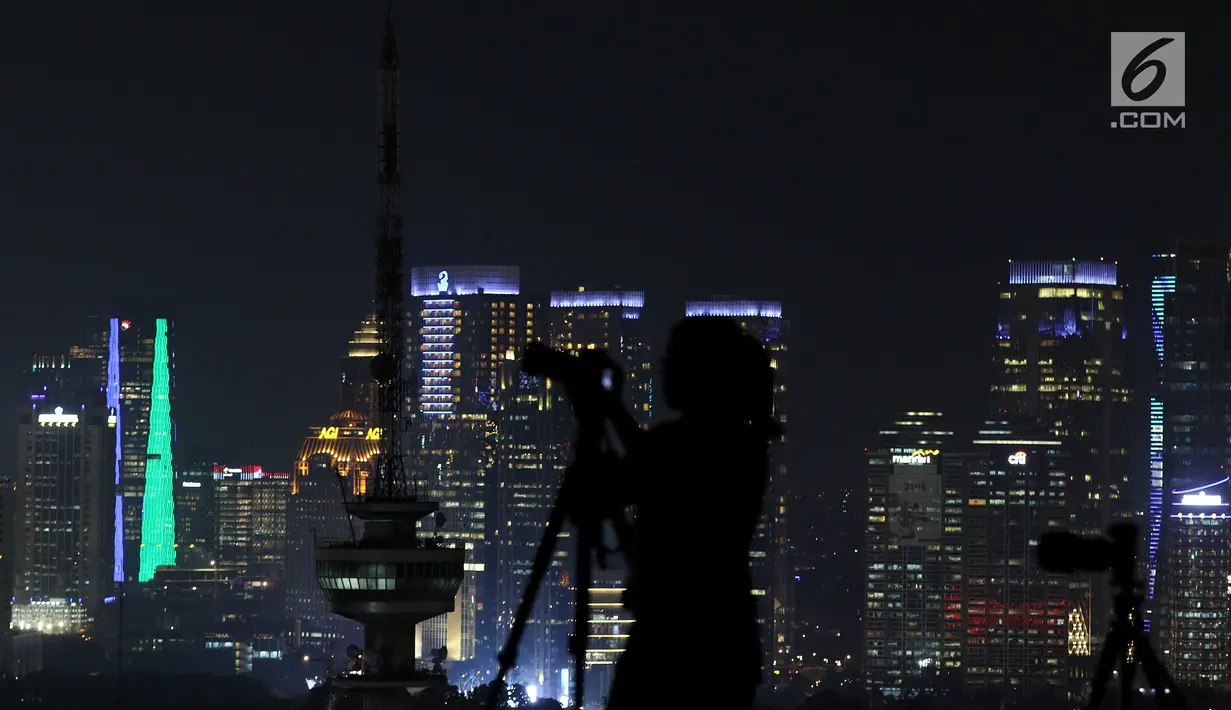 Pemandangan saat pecinta fotografi mengabadikan fenomena gerhana "Super Blue Blood Moon" dengan latar belakang gedung bertingkat dari atas Gedung MPR/DPR Senayan, Jakarta, Rabu Malam (31/1). (Liputan6.com/Johan Tallo)