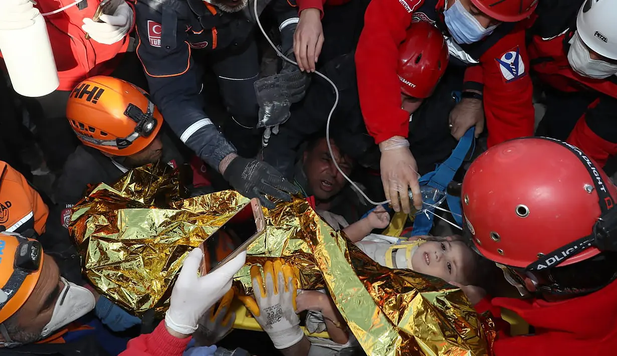 Petugas penyelamat membawa Ayda Gezgin, 3, keluar dari reruntuhan gedung apartemen setelah gempa bumi dahsyat di kota Izmir, Turki, Selasa (3/11/2020). Ayda Gazgin berhasil diselamatkan dari bawah reruntuhan bangunan setelah terkubur selama 4 hari atau sekitar 91 jam. (AFAD via AP)