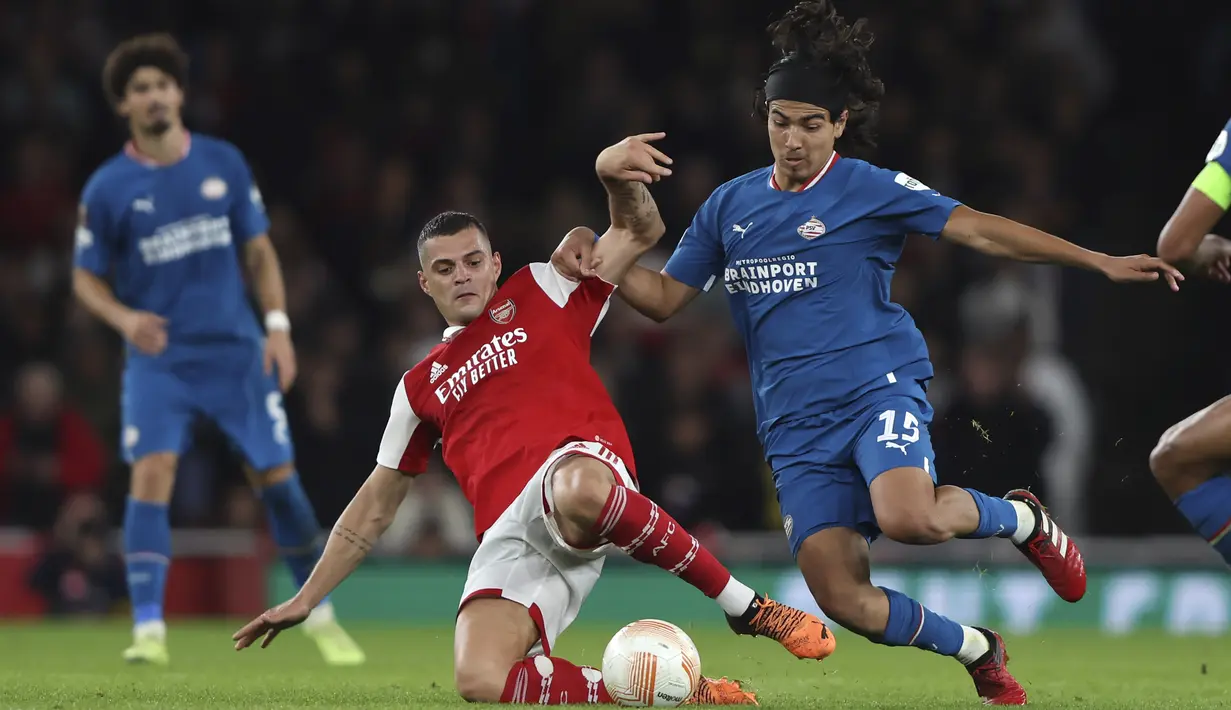 Gelandang Arsenal, Granit Xhaka berebut bola dengan pemain PSV Eindhoven, Erick Gutierrez selama pertandingan lanjutan Liga Europa di stadion Emirates di London, Kamis, 20 Oktober 2022. Arsenal menang tipis atas PSV 1-0. (AP Photo/Ian Walton)